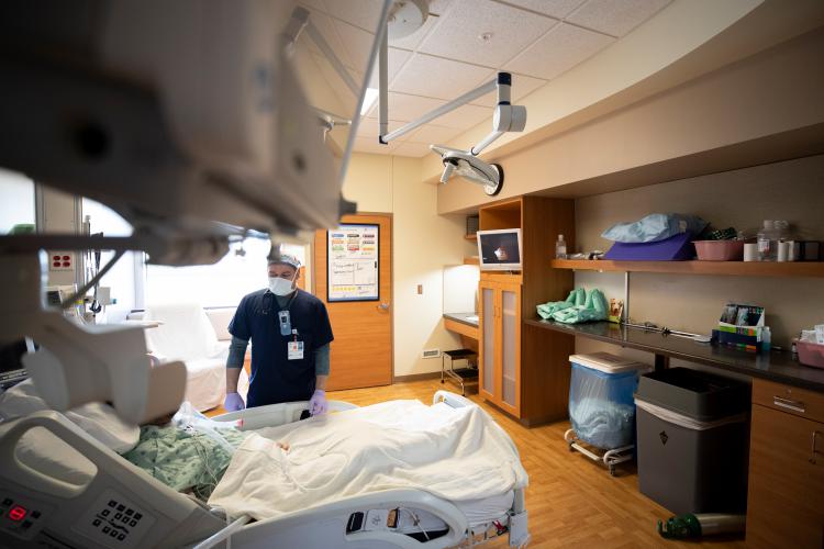 A JPS Health Network team member talks with a patient in their room.