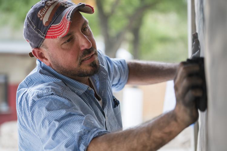 Jimmy Jenkins works on a mural at the Fort Worth Zoo