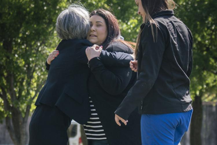 Emily Avila, center, receives a hug from Lee Ann Franklin
