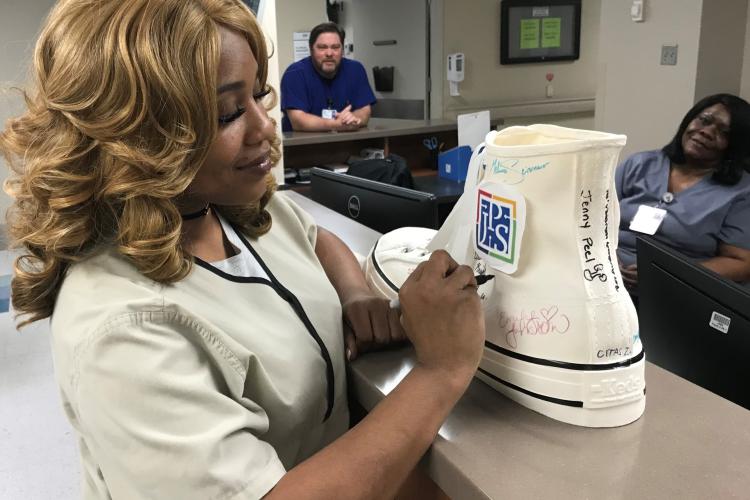 Multi-Skilled Tech Sherica Owens signs the Walk the Walk Shoe