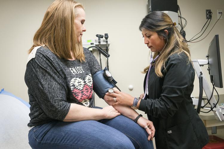 Klabzuba Clinic patient Valerie O'Brien, from left, has her blood pressure checked by CMA Denise Moreno