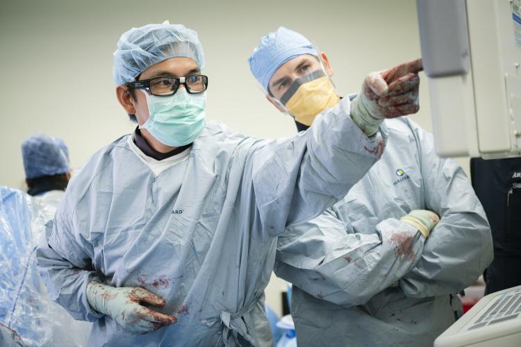 Orthopedic Trauma Surgeon Dr. Bryan Ming, from left, points to an x-ray as Orthopedic Resident Dr. Michael Wheeler looks on