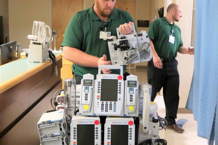 Clinical Engineering team members place infusion pumps