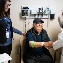 JPS Health Network interpreter Dianna Rodriguez (L) shares with patient Jesus Villalobos the results of his examination by Dr. Kalyani Narra (R). 