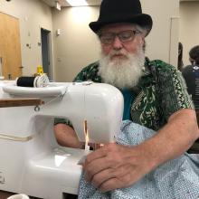 JPS volunteer sewing a quilt