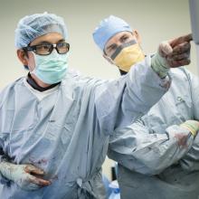 Orthopedic Trauma Surgeon Dr. Bryan Ming, from left, points to an x-ray as Orthopedic Resident Dr. Michael Wheeler looks on